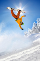 Wall Mural - Snowboarder jumping against blue sky