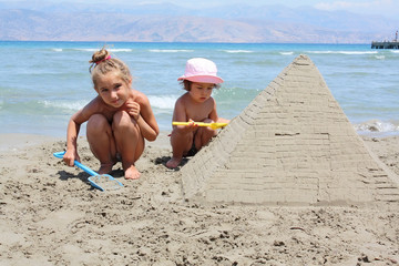 children make sandy pyramid