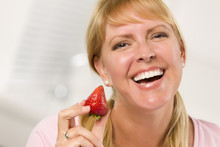 Pretty Smiling Blonde Woman Holding Strawberry