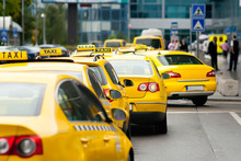 Yellow Taxi Cabs Waiting In Front Of Airport Terminal