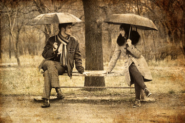 Two sitting at bench in rainy day. Photo in old image style.