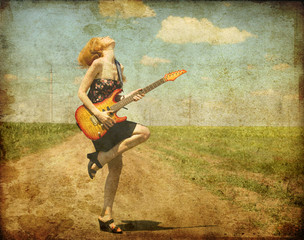 Rock girl with guitar at countryside.