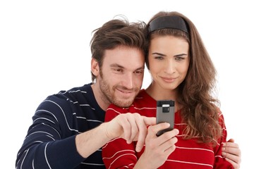 Wall Mural - Happy couple using mobile phone smiling