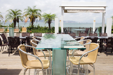 Wall Mural - Beach cafe with  tables and chairs placed at the sea waterfront