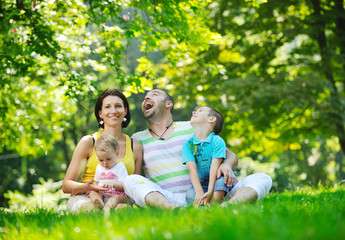 happy young couple with their children have fun at park