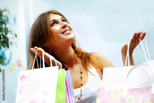 Fotografie, Obraz Shopping woman with lots of bags smiles inside mall. She is happ