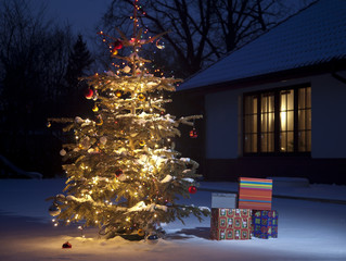 christmas tree outside house with gift boxes