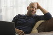 © Patrick Lane/Blend Images - Mixed race man sitting in chair with laptop