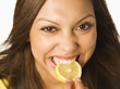 © Jasper Cole/Blend Images - Close up of Hispanic woman biting lemon slice