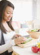 © JGI/Jamie Grill/Blend Images - Smiling mixed race teenage girl cutting vegetables