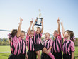 © Erik Isakson/Blend Images - Cheering girl soccer players posing with trophy