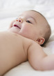 © JGI/Jamie Grill/Blend Images - Mixed race baby laying on bed