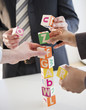 © JGI/Jamie Grill/Blend Images - Business people stacking alphabet blocks