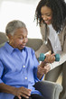 © JGI/Tom Grill/Blend Images - Nurse helping woman exercise with dumbbells