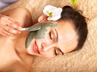 Young woman  having clay body mask.