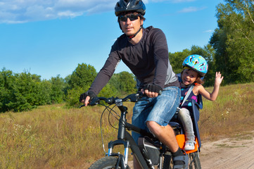 family cycling. father with kid riding bicycle outdoors