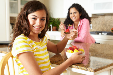 Wall Mural - Mother and daughter eating cereal and fruit