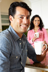 Canvas Print - Hispanic couple relaxing in kitchen