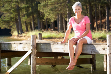 Senior woman sitting by lake