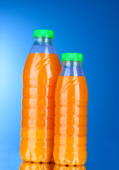 Bottles with juice on blue background