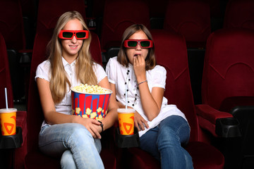 Two young girls watching in cinema