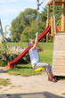 Fun in the park. Girl pulls down the hill on a rope