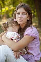 sad little girl and mother in the park