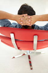 Wall Mural - Young man relaxing in red chair