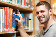 © WavebreakmediaMicro - Smiling male student picking a book