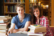 © WavebreakmediaMicro - Smiling students surrounded by books