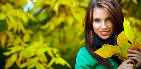 Wall Mural - Beautiful elegant woman standing in a park in autumn