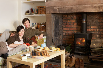 Wall Mural - Young couple relaxing by fire