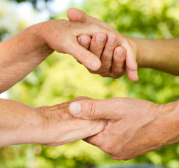 Closeup of senior hands holding together