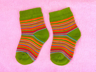 bright baby socks on pink background