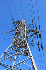 high voltage post against the blue sky