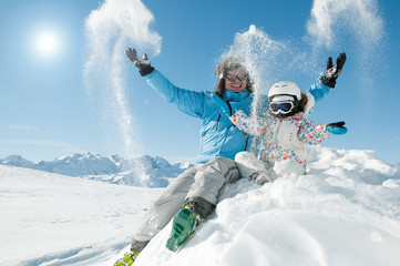 Fototapete - Winter fun - happy skiers playing in snow