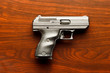 Top view of 9 mm handgun against wooden surface
