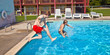 © travelview - brothers have fun jumping in the pool