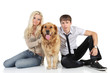 © VitCOM - A young family with a dog sitting on floor, looking at camera