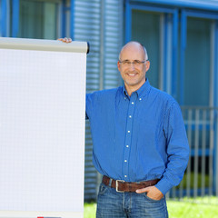 Wall Mural - geschäftsmann steht am flipchart vor dem bürogebäude