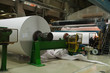 Massive rolls of paper in front of industrial equipment