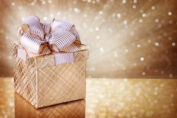 Sticker - Christmas gift box on golden background