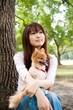 © taka - attractive asian woman with dog in the park