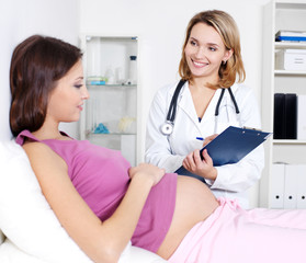 Pregnant young woman with doctor at clinic