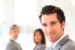 © goodluz - Portrait of smiling businessman standing in hall