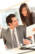 © goodluz - Business team using electronic tablet at work