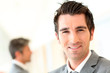 © goodluz - Portrait of smiling businessman standing in hall