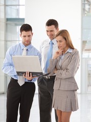 Poster - Young businesspeople looking at laptop screen