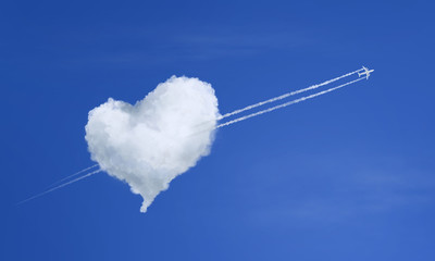 Airplane flying through heart shaped cloud