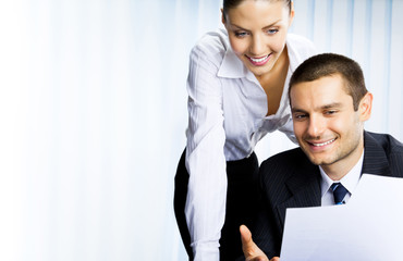 two businesspeople working with document at office